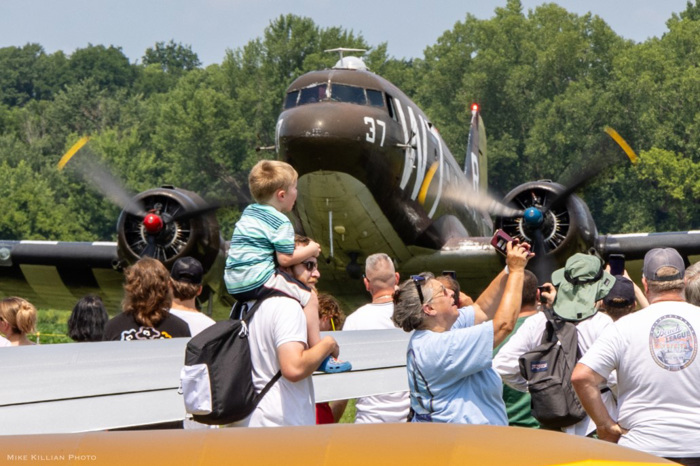 Guided tour group examining aircraft